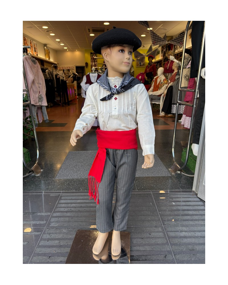 Haur euskal jantzia, alkandora brodatua lauburus – gerriko gorria eta galtza marradunak dituena