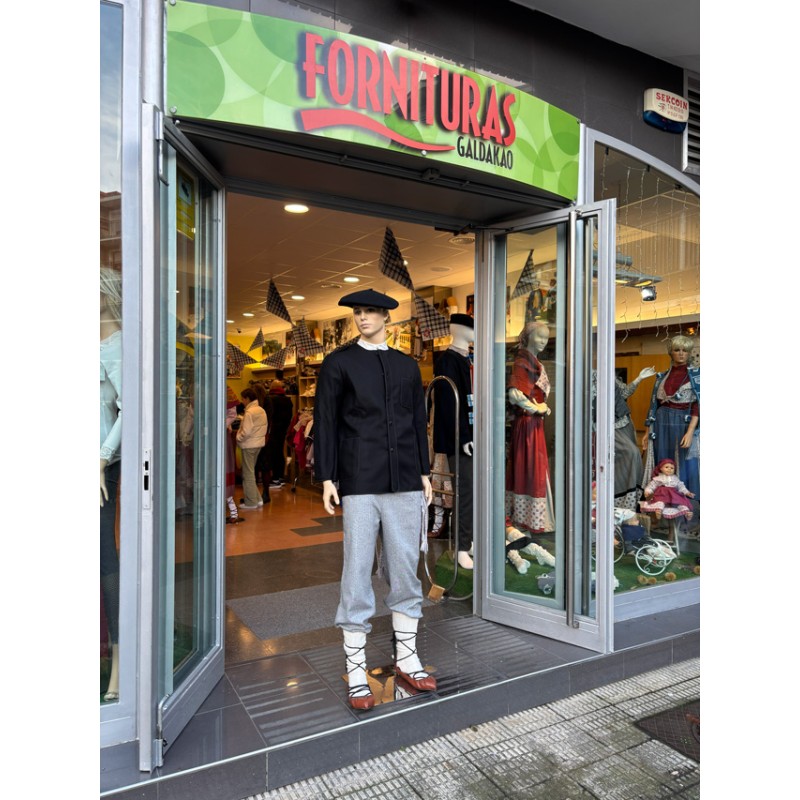 Euskal jantzi tradizionalez forratutako kaiku beltza