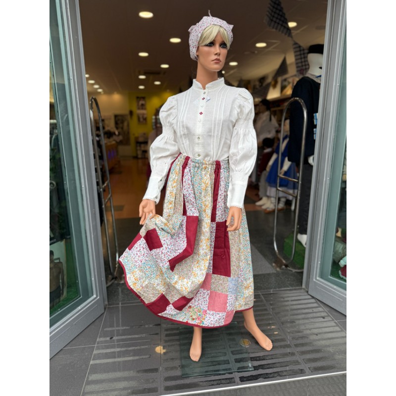 Euskal jantzi tradizionala, lauburu granatez brodaturiko blusarekin eta patchwork gonarekin