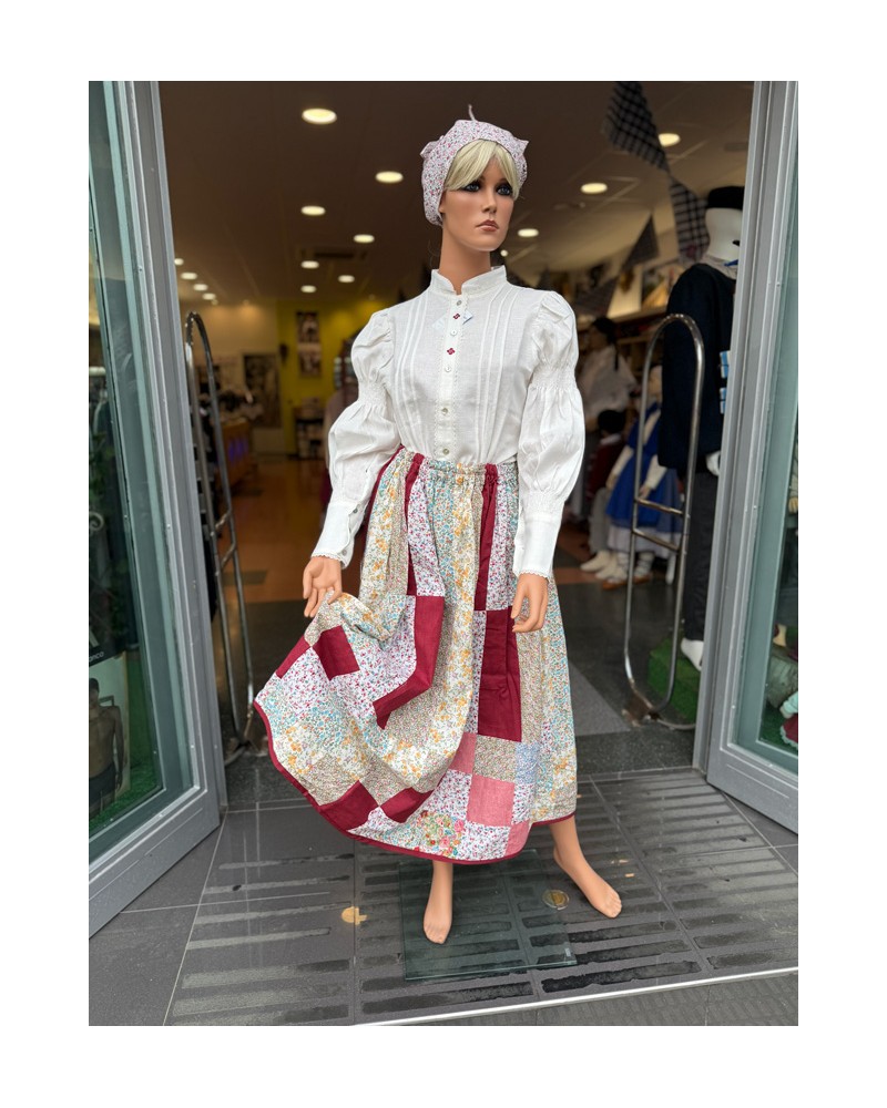 Euskal jantzi tradizionala, lauburu granatez brodaturiko blusarekin eta patchwork gonarekin