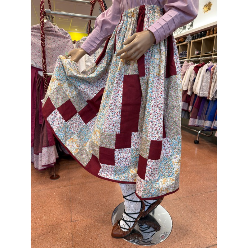 Euskal jantzi tradizionala, lauburu granatez brodaturiko blusarekin eta patchwork gonarekin