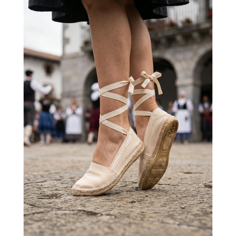 Alpargatas vascas beige con cintas atadas al tobillo