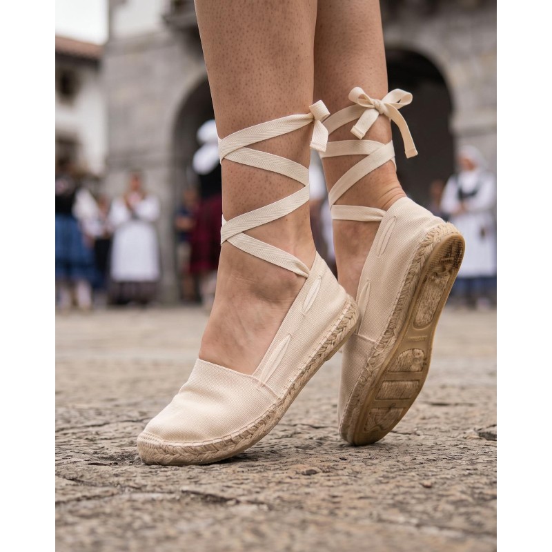 Alpargatas vascas beige con cintas atadas al tobillo