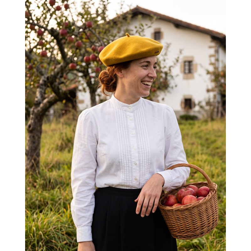 Mujer con boina vasca mostaza y blusa vasca de lorzas