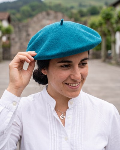 Mujer con boina vasca turquesa y blusa vasca de lorzas