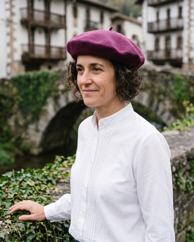 Mujer con boina vasca morada y blusa vasca de lorzas